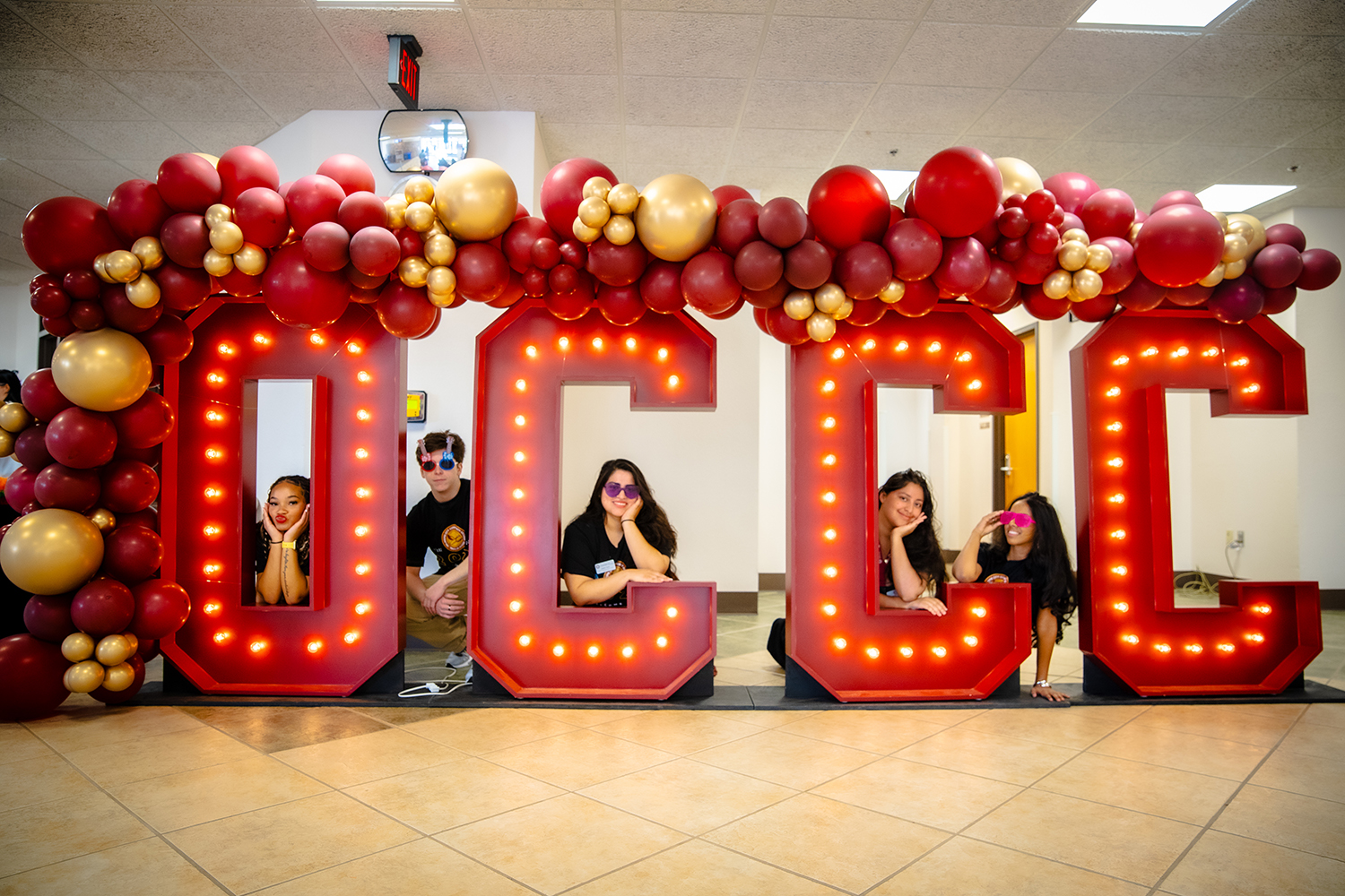 Oklahoma City Community College students with a lighted OCCC sign.