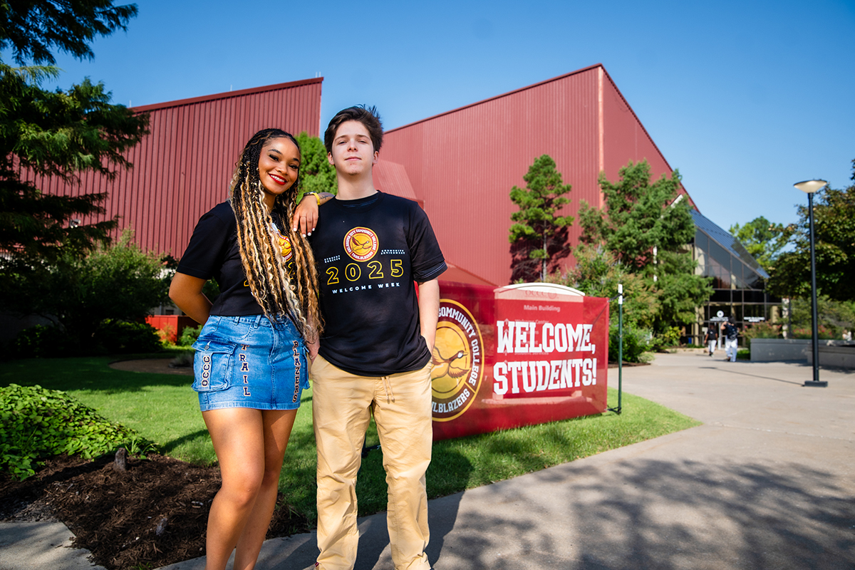 Two students stand in front of the main building of Oklahoma City Community College.